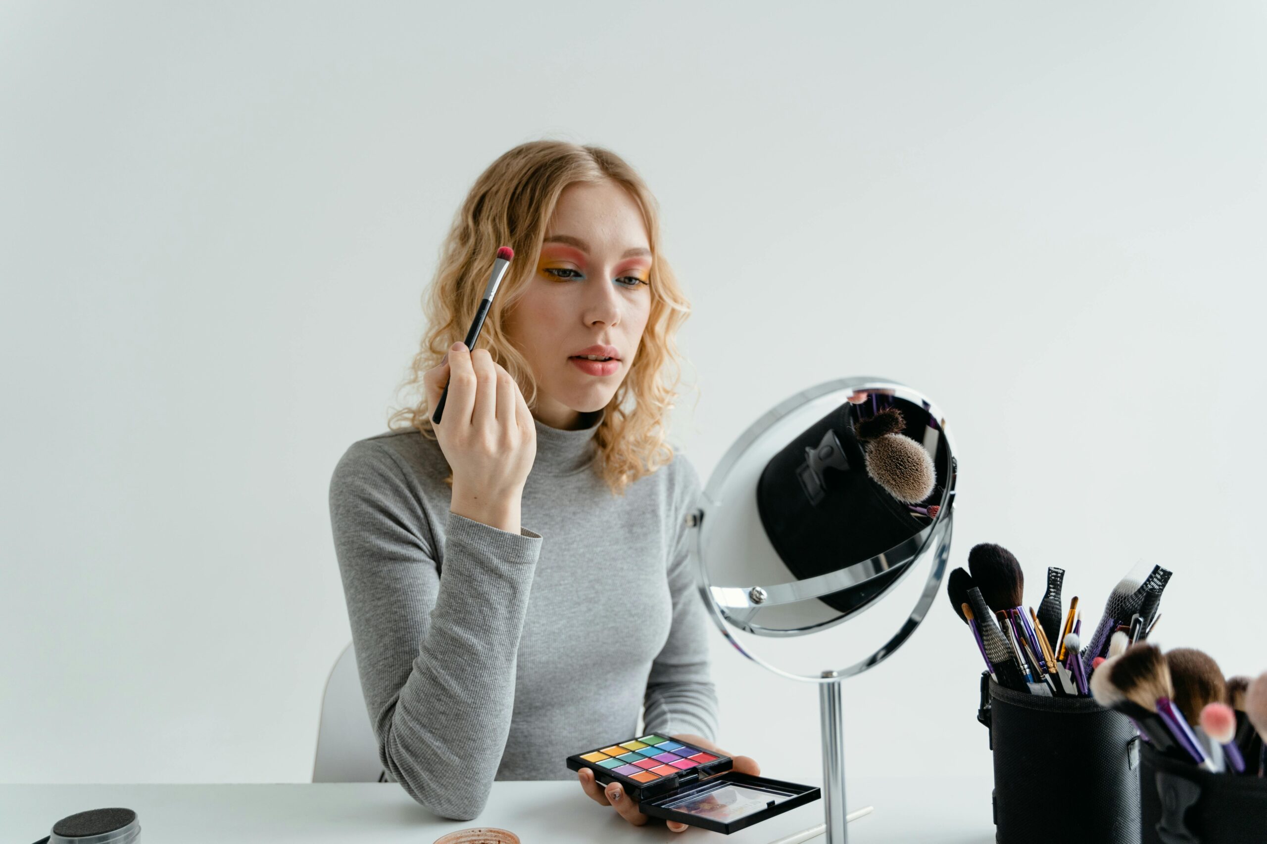 A collection of tools used for applying waterproof makeup including brushes and primers