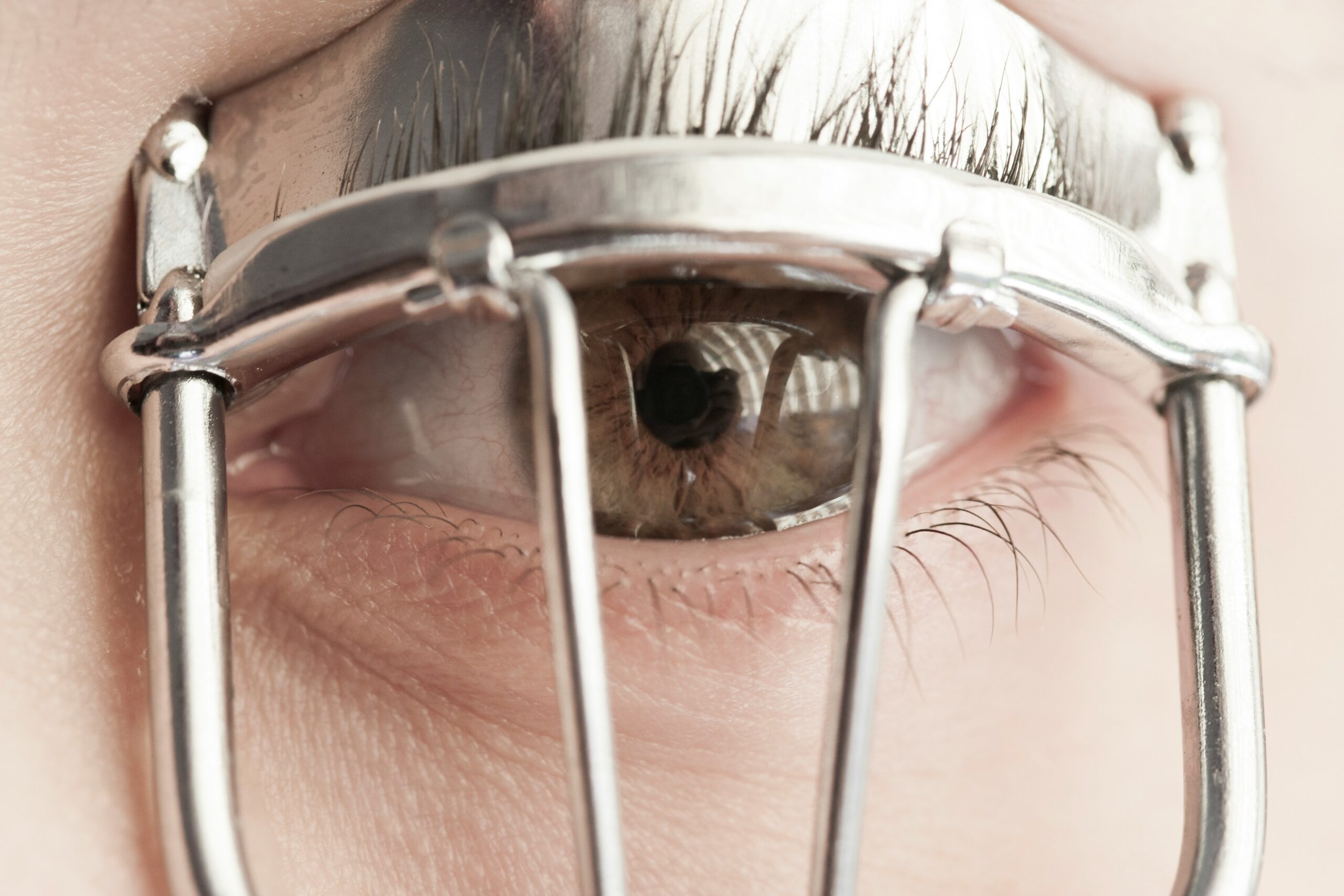 A high-quality image of an eyelash curler being used on someone's eyelashes