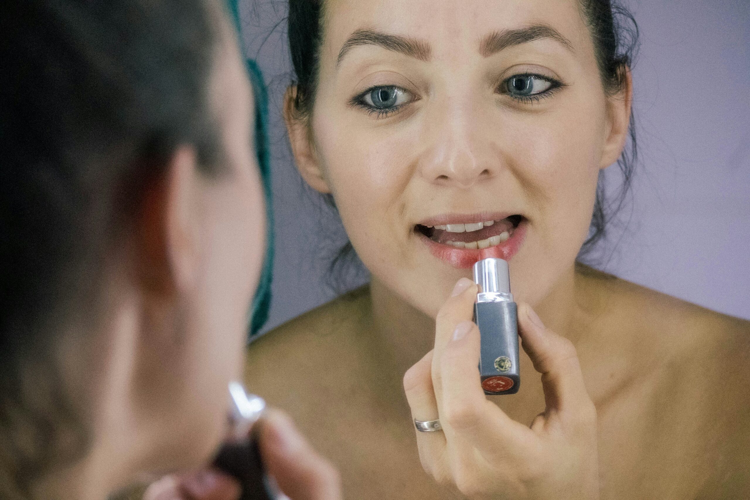 Person holding multiple waterproof makeup products, examining them closely
