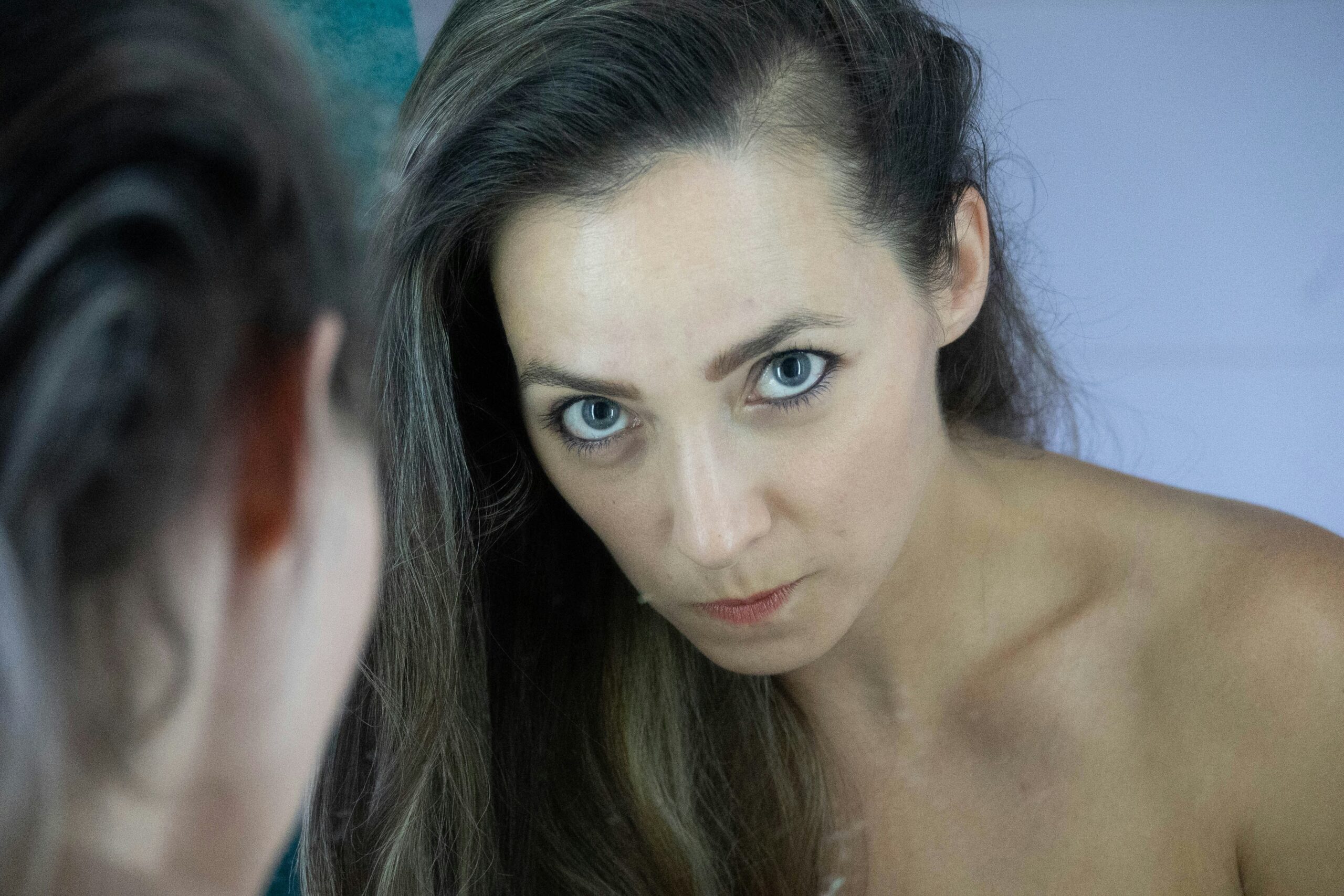 Woman touching her face, looking frustrated with flaky makeup