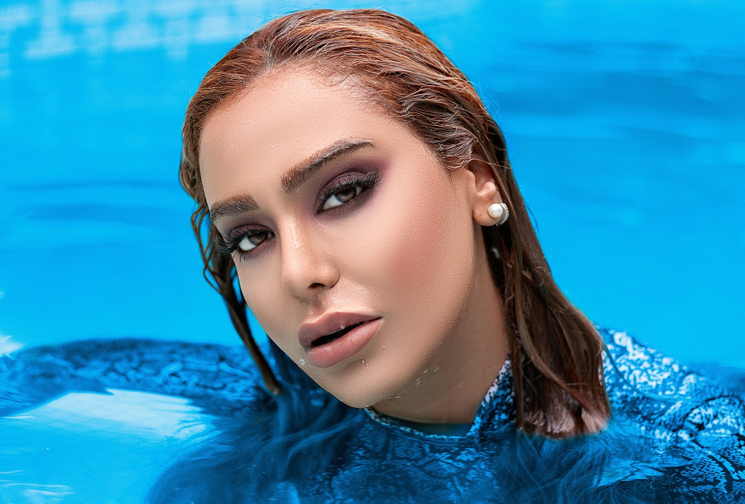 Makeup artist using a damp sponge to set foundation with translucent powder