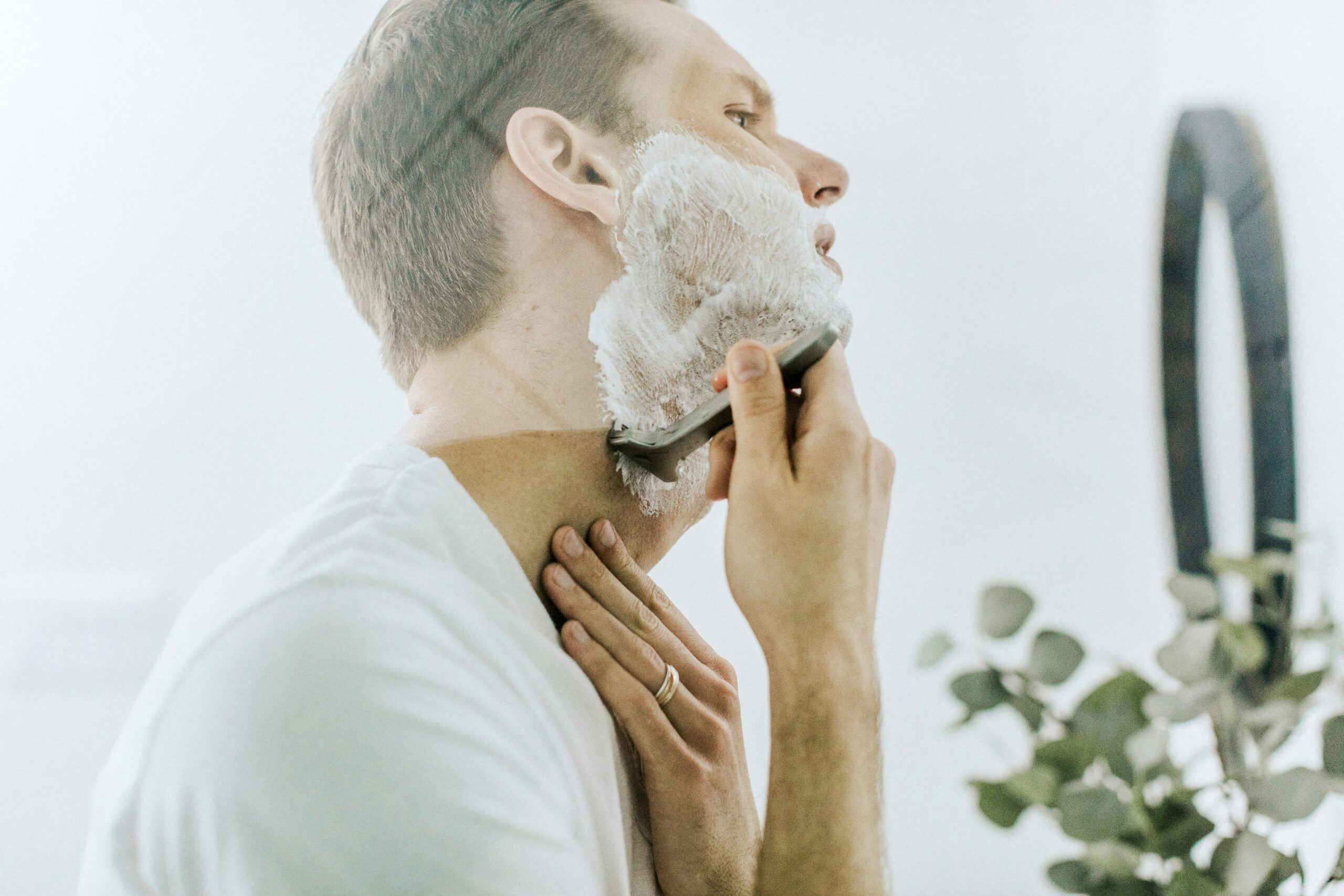 Person blending liquid foundation onto their face using a damp sponge.