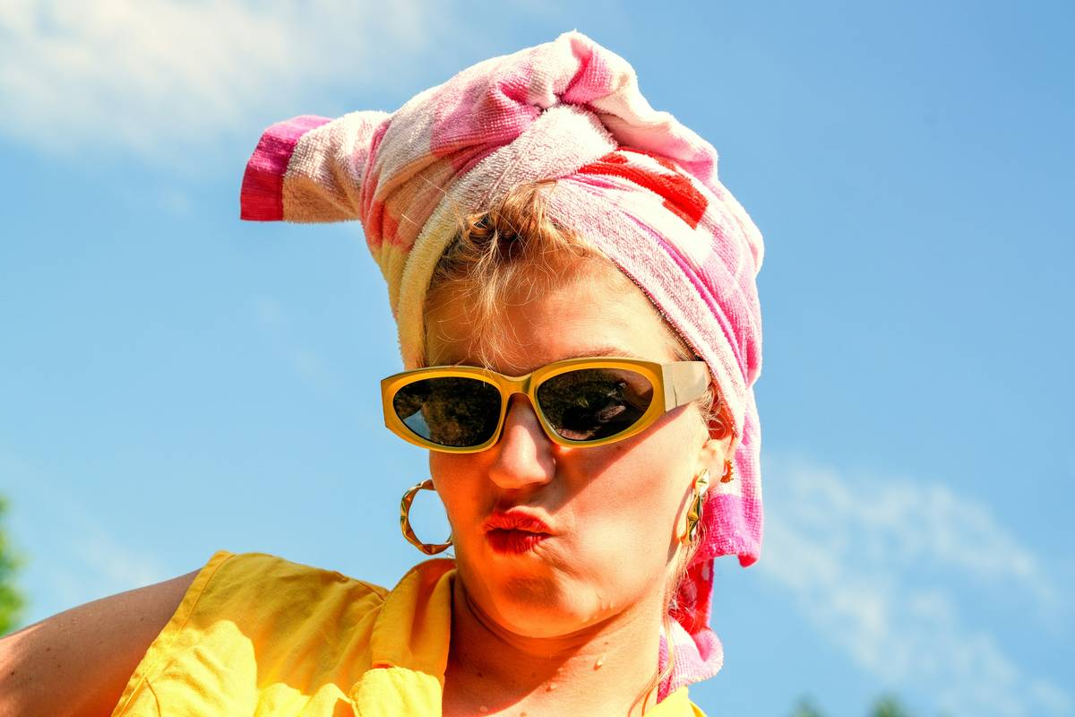 A bride posing outdoors while her flawless makeup remains intact despite the heat.