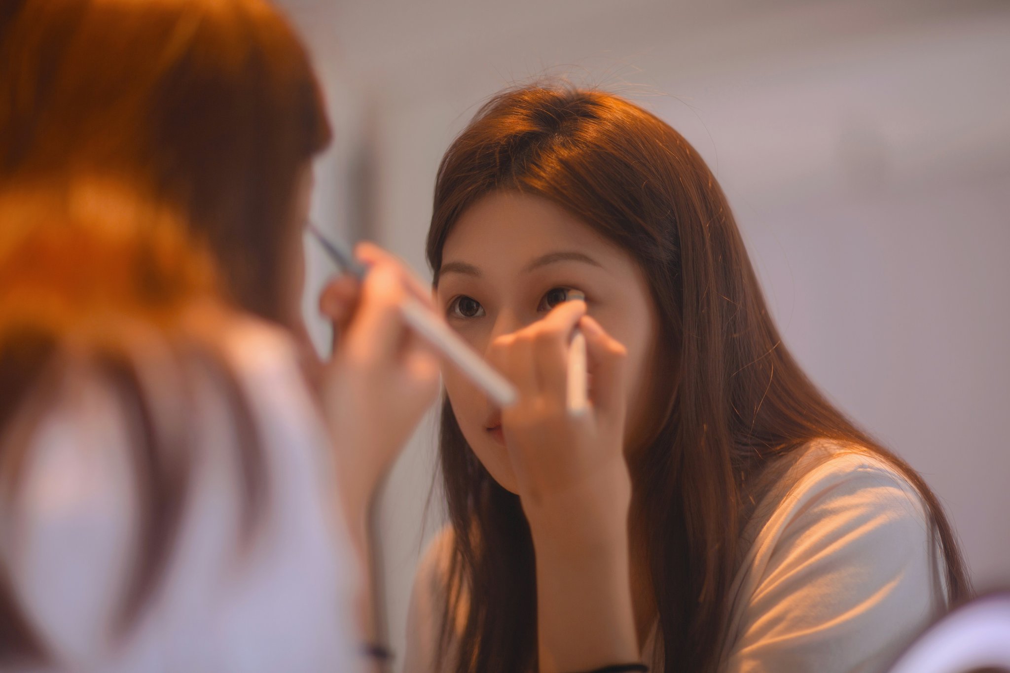 A small bottle of setting spray being sprayed over someone's face.
