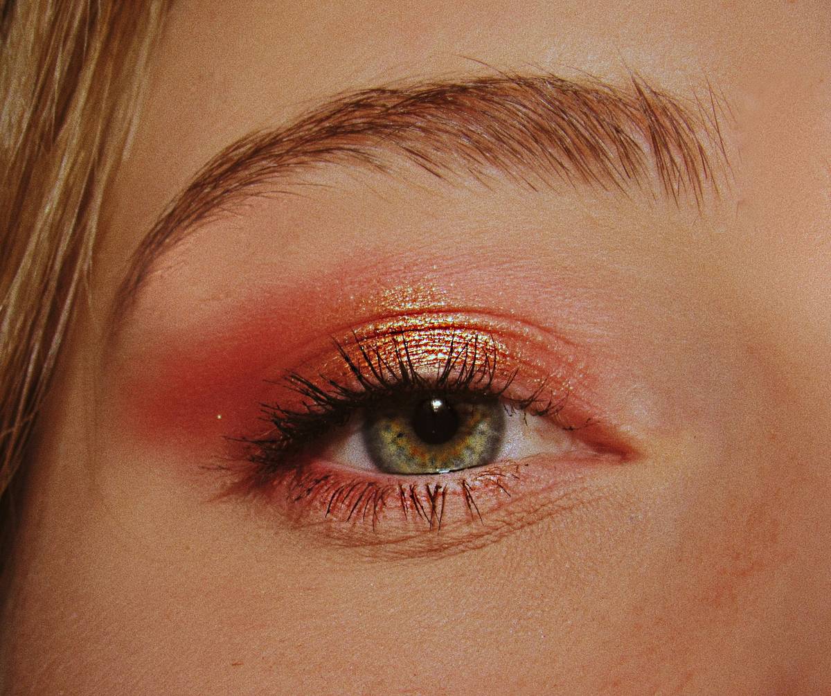 A woman touching her face as her makeup smudges due to heat.