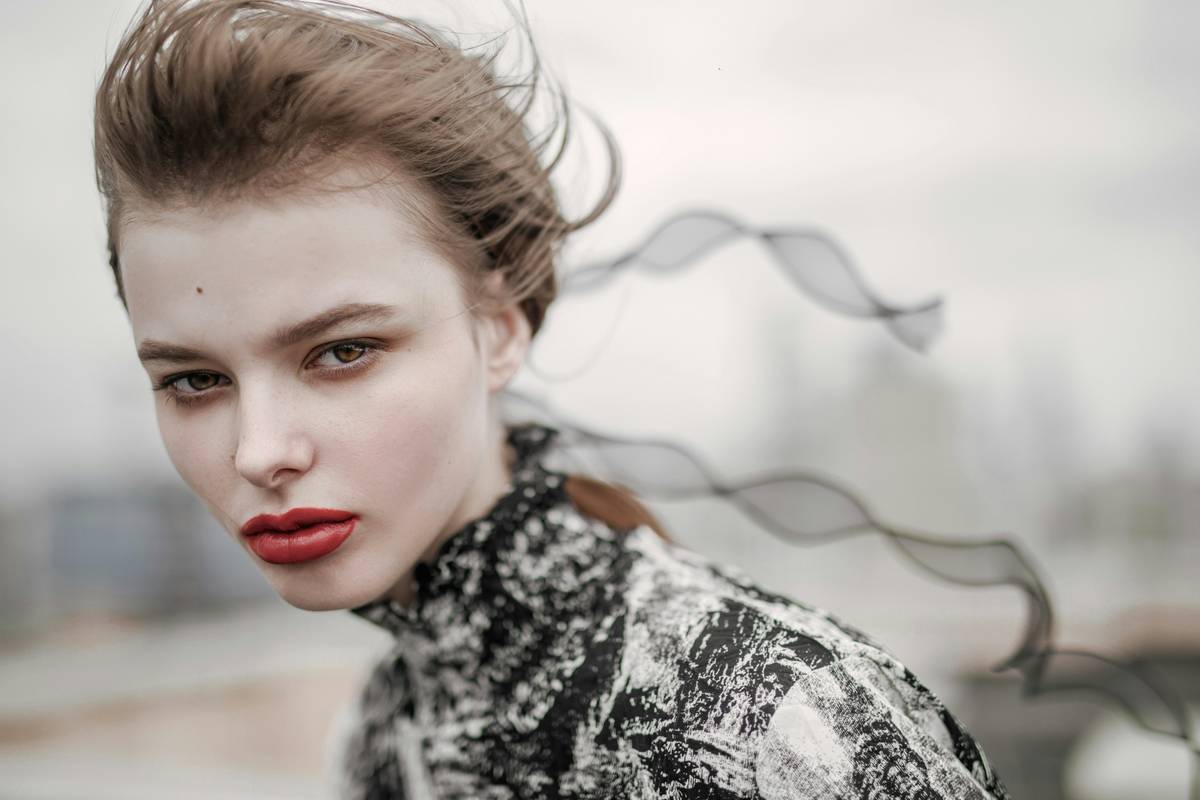 A woman wearing windproof makeup while standing confidently in strong winds.