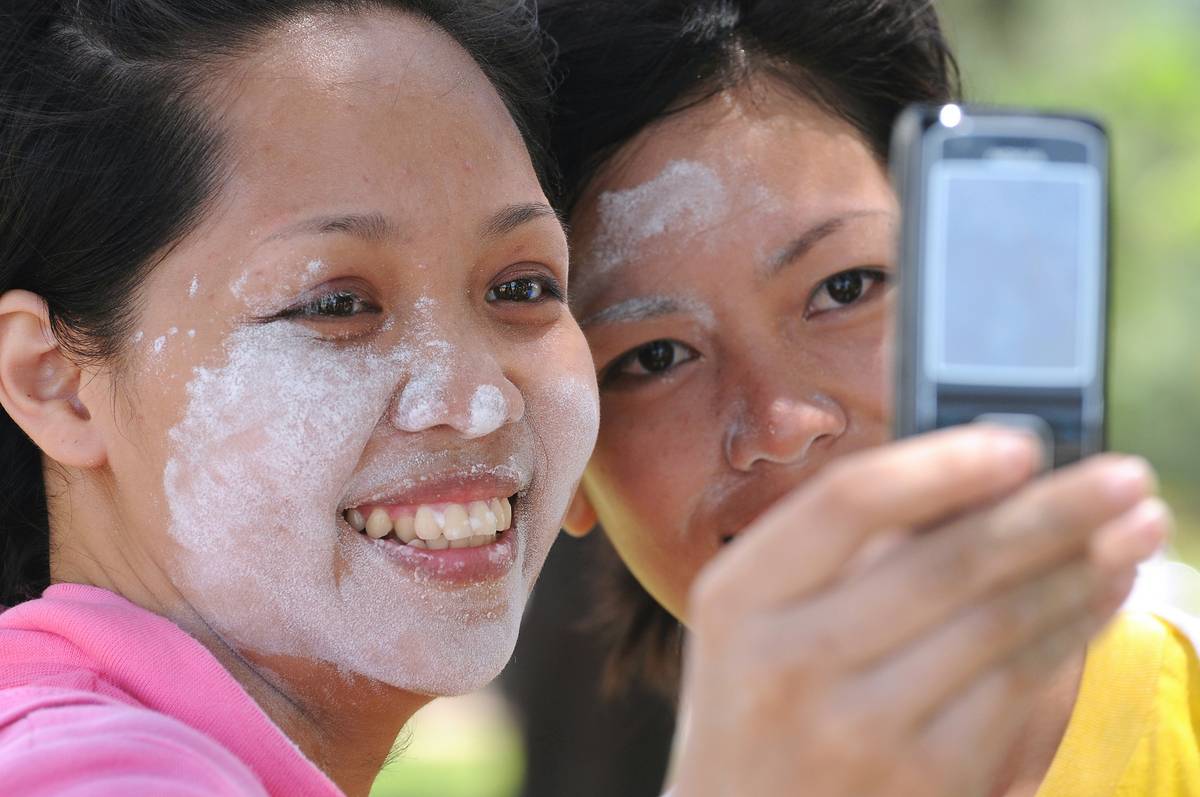 A sweaty runner smiling with intact makeup at the end of a race.