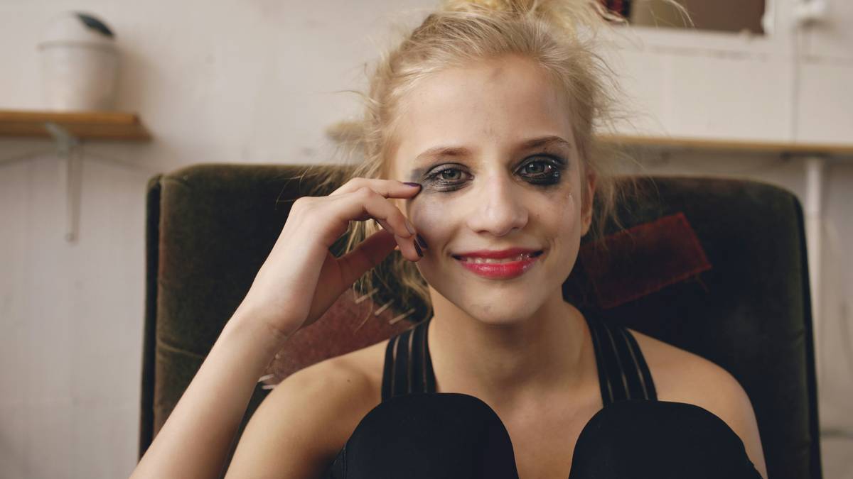 A woman applying storm resistant powder on her face outdoors