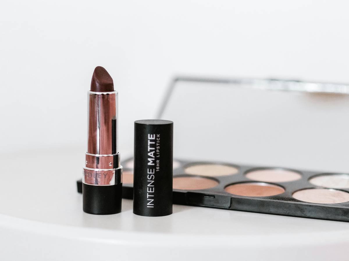Infographic comparing effective vs ineffective ingredients in smudge proof balms. Left side shows film-forming polymers like acrylates copolymer; right shows waxes and oils that melt easily.