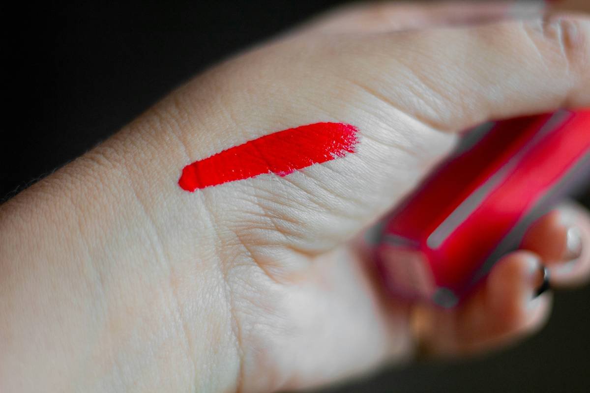 Infographic showing how film-forming polymers in waterproof makeup bind to skin and trap pigment, causing persistent stains